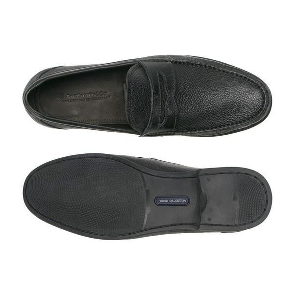 A top-down view of the Anatomic Castelo Black Driver Shoes, with one shoe flipped upside down to reveal the Anatomic Gel Technology® sole. This shot emphasizes the non-slip, flexible sole and the meticulous detail in the leather upper, combining function with style.