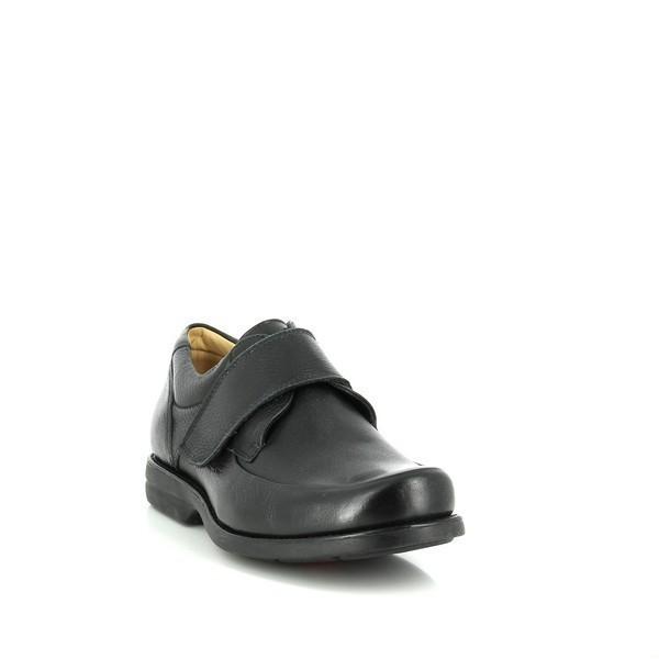 The shoe is angled to highlight the elegant curve from the toe to the heel. The burnished black leather finish gives the shoe a vintage yet sophisticated look, while the Velcro strap provides modern functionality.