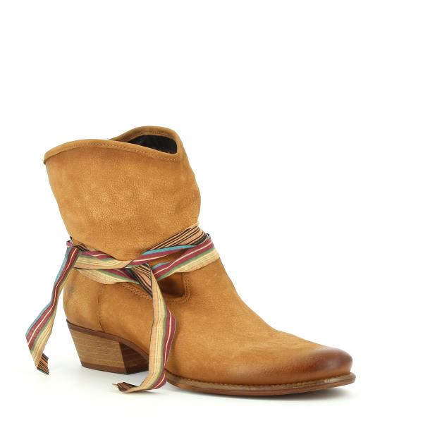 Captures the ankle boot from a slight angle, highlighting the contours of the boot and the elegant heel, as well as the intricate design of the straps across the side.