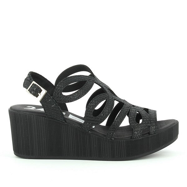 The 24Hrs 24567 Charcoal Black Slingback Wedges are displayed on a simple background, emphasizing their sleek design. The shoes feature a rich charcoal black leather upper with a smooth finish, a rounded toe, and a 5cm wedge heel. The adjustable slingback strap and sturdy synthetic sole are clearly visible, showcasing their blend of style and comfort.