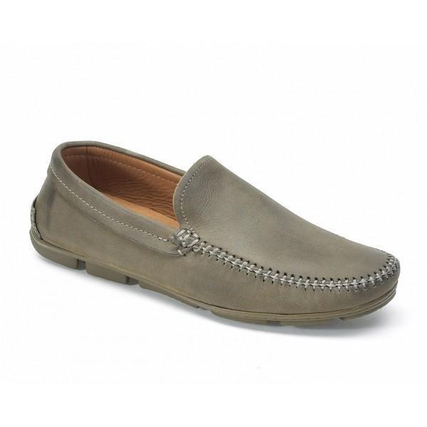 This angled shot of the Anatomic Aruja Chumbo Grey Driver Shoe highlights its sleek, modern design and smooth leather upper. The photograph captures the shoe's refined contours and sophisticated grey hue, emphasizing the quality craftsmanship and the elegant silhouette.