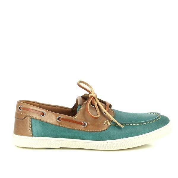 A profile view showcasing the rich green Pinhao leather upper with a smooth, polished finish. The classic boat shoe design is highlighted, featuring a rounded toe and detailed stitching along the edges, complemented by the subtle sheen of the leather.