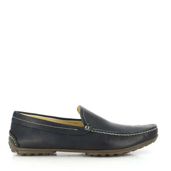 A profile view of the Anatomic Lucas Navy Boat Shoes, showcasing the smooth navy leather upper. The classic boat shoe design features detailed stitching and a rounded toe, emphasizing the shoe’s refined and timeless appearance.