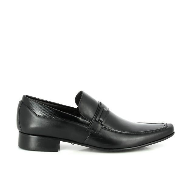 The Anatomic Wyting Black Driver Shoes are displayed from the side, showcasing their smooth, black leather upper with a clean, streamlined silhouette. The round toe and 2cm heel height are visible, along with the cushioned footbed slightly peeking out from the edge. The shoe’s sophisticated burnished finish and natural leather texture highlight its premium craftsmanship.