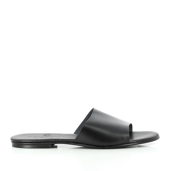 This side view displays the sleek profile of the slides, emphasizing the smooth black leather upper. The minimalist design is evident, with clean lines that exude sophistication. The subtle sheen of the leather catches the light, enhancing the overall aesthetic.