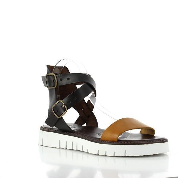 This angle captures the sandals from a stylish perspective, emphasizing the slight arch of the sole and the graceful slingback strap. The interplay of light on the leather adds depth, showcasing the intricate stitching details and the luxurious quality of the materials used.