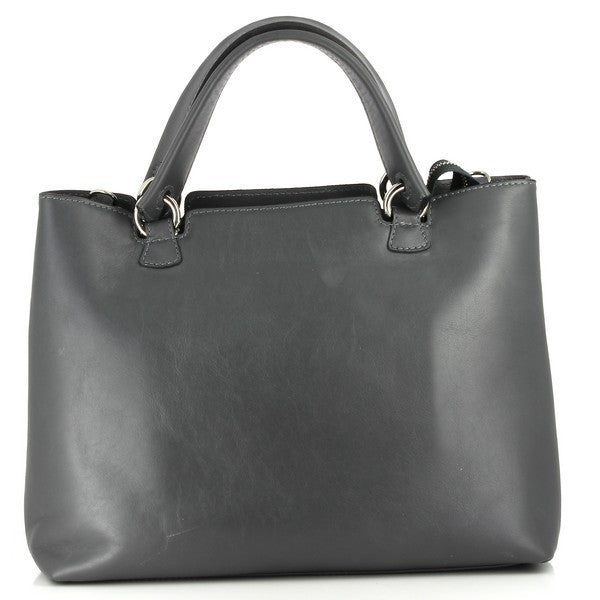 The Bridas 857 Fummo Grey Handbag is displayed on a soft, neutral background, accentuating its elegant grey leather exterior. The bag has a sleek, structured shape with a spacious interior, ideal for daily essentials. Its fine leather texture and subtle grain are highlighted, showcasing the quality craftsmanship. The adjustable strap is shown draped alongside the bag, emphasizing its versatility. 