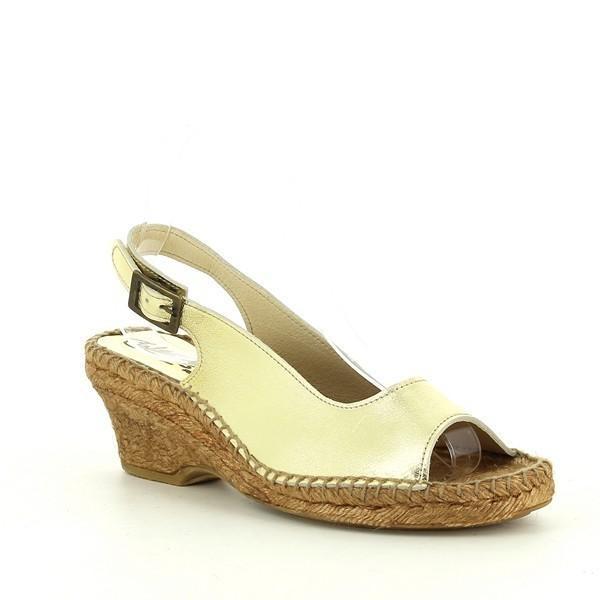 The angled side shot captures the unique peep-toe design and slingback strap, giving a sense of the shoe’s comfortable yet sophisticated fit. The layered texture of the handwoven jute sole and the golden leather create a striking contrast.