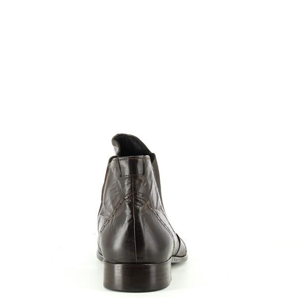 The angled view showcases the elegant curve of the boot, emphasizing the polished brogue accents and the subtle shine of the dark brown leather. The 2 cm heel and lightweight rubber outsole are visible, offering a blend of comfort and style.