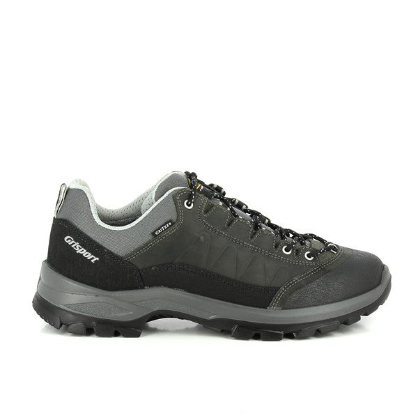 This image showcases the Grisport 14509D5G Grey Trekking Sneakers from the side, highlighting the smooth leather upper in a stylish grey tone. The round toe shape is visible, providing a roomy and comfortable fit. The synthetic sole with its rugged tread offers a clear view of its durable construction, ideal for trekking and outdoor activities. The lacing system is neatly arranged, ensuring a secure and adjustable fit.