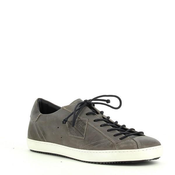 The angled view of the sneaker highlights the lace-up closure and the smooth brown leather upper, paired with the clean lines and refined stitching along the sides.