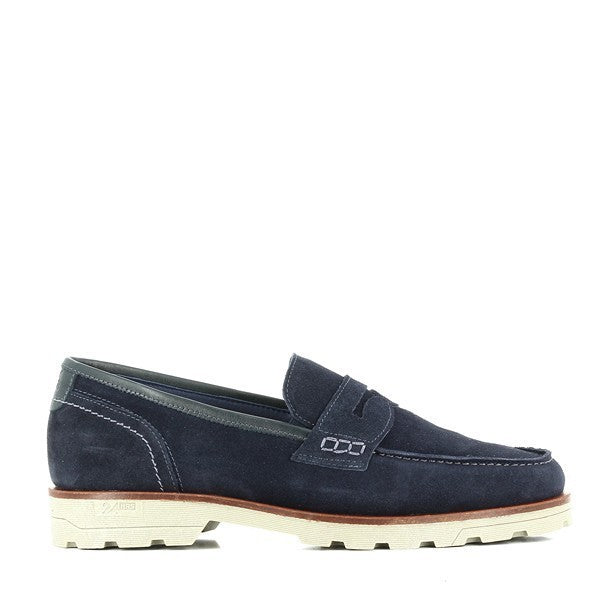 A pair of 24 Hrs 10361 Navy Slip On Loafers, elegantly crafted from premium leather. The loafers feature a classic round toe, soft leather lining, and a durable synthetic sole with a 3 cm heel-platform height. Showcased against a neutral backdrop, the shoes highlight their sleek, sophisticated design and high-quality craftsmanship.