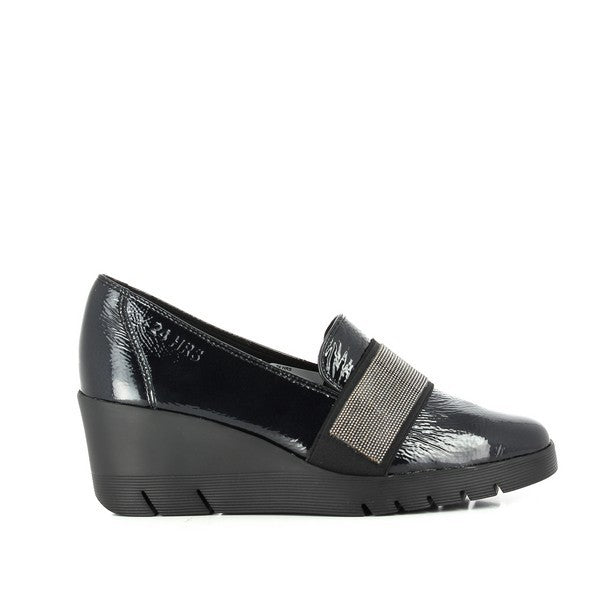 A close-up shot of the 24 Hrs 23450 Black Loafers, showcasing their sleek leather upper and round toe shape. The loafers feature a 6 cm heel-platform, offering a slight lift while maintaining a classic silhouette. The soft leather lining and durable synthetic sole are also visible, highlighting the quality craftsmanship and attention to detail in these elegant women's shoes. The photo captures the refined, minimalist design that makes these loafers a versatile addition to any wardrobe.