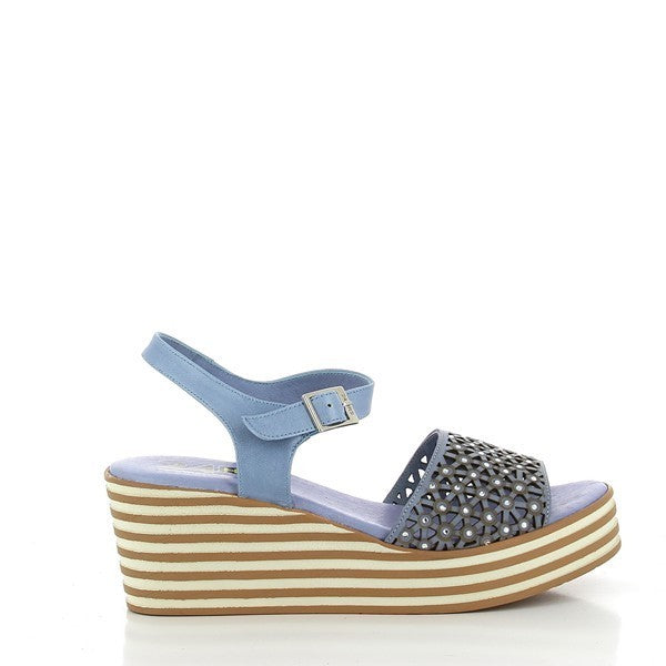 A pair of 24 Hrs 24106 Light Blue Slingback Wedges is displayed on a neutral background. The wedges feature a soft light blue leather upper with a round toe and an elegant slingback design. The 5.5 cm heel offers a chic lift, while the synthetic sole provides stability. The soft leather lining is visible from the top, emphasizing comfort and craftsmanship. The overall design exudes a refined, stylish look that complements both casual and dressy outfits.