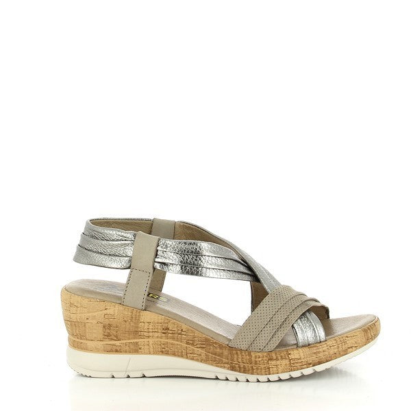 A pair of 24HRS 24128 Cana Silver Slingback Wedges for women, elegantly crafted with a shiny silver leather upper and a rounded toe design. The wedges feature a 5.5 cm heel with a sturdy synthetic sole, and a secure slingback strap. The shoes are shown against a plain background, highlighting their sleek design and handcrafted details.