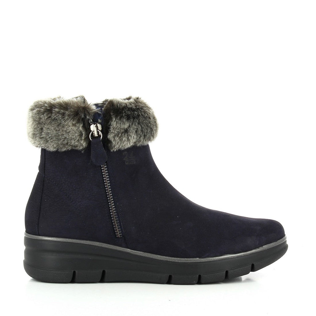 A pair of 24HRS 24295 Navy Ankle Boots displayed from an angled side view, highlighting the rich navy leather upper and the chic fur lining visible at the top. The image also features the functional external zipper on the side, the 3.5 cm heel-platform, and the round toe shape, emphasizing the boots' blend of style and practicality.