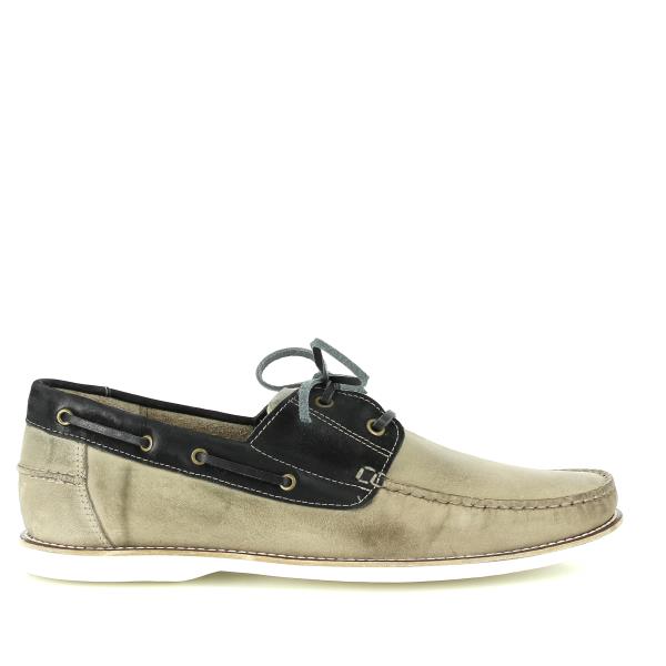 A pair of Anatomic Dockstep Castor Boat Shoes is displayed, showcasing their rich, full-grain leather uppers with a burnished finish for a vintage look. The classic boat shoe design includes lace detailing around the collar and a round toe shape. The shoes rest on a neutral surface, highlighting the flat heel and non-slip rubber sole. The soft sheepskin lining is visible, emphasizing the comfort and craftsmanship of these handcrafted men's shoes. The rich brown color and fine stitching details are captured,