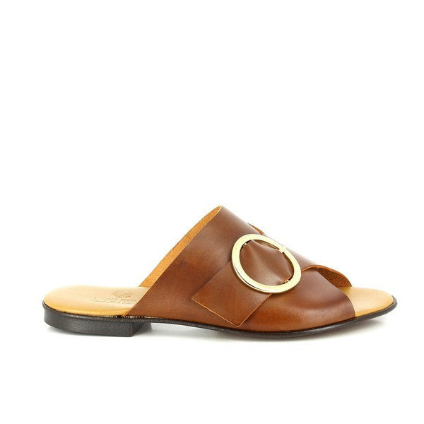 A pair of Antichi Romani 2011 Cuoio Tan Slides is elegantly displayed against a neutral background. The slides feature rich tan leather with a decorative strap adorned with a round golden buckle, adding a touch of sophistication. The 2 cm heel provides a subtle lift, while the round toe design ensures a classic and comfortable fit. The leather upper and lining highlight premium Italian craftsmanship, and the synthetic sole is designed for durability and flexibility. 