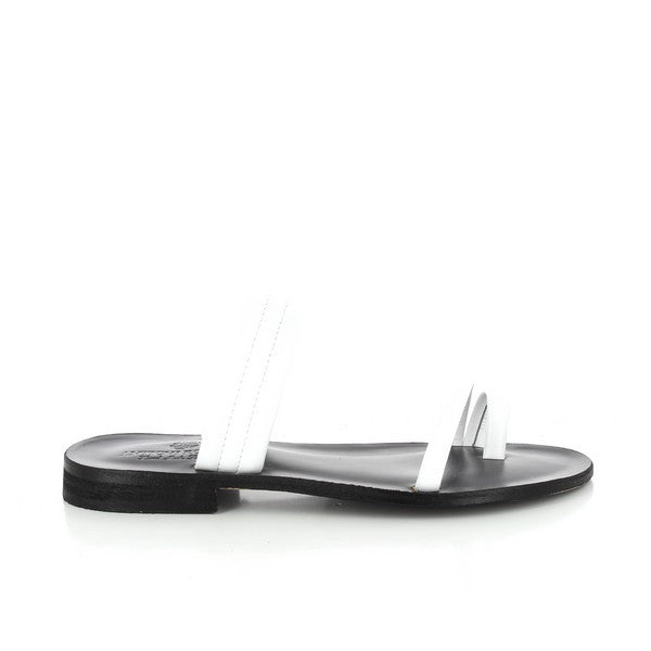 A pair of Antichi Romani 2017 Bianco White Slides is elegantly presented against a neutral background. The slides feature pristine white leather with a sleek, minimalist design. The 2 cm heel adds a subtle lift, while the round toe shape ensures a classic and comfortable fit. The leather upper and lining highlight exceptional Italian craftsmanship, and the synthetic sole offers durability and flexibility. The overall look is refined and versatile, ideal for complementing various outfits.