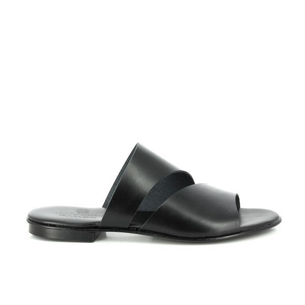 The photo features a pair of Antichi Romani 511 Nero Black Slides, showcasing their sleek and minimal design. The slides have a simple, elegant silhouette with a round toe and a smooth black leather upper, exuding a sense of timeless Italian craftsmanship. The 2cm platform heel adds a subtle lift, while the synthetic sole provides a light, flexible base. The leather lining inside the slides hints at the quality and comfort these women's shoes offer. 