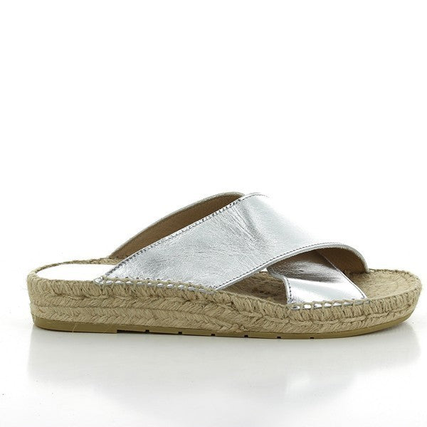 A pair of Calzanor 1809 Cross-Strap Espadrilles in a stunning silver hue, showcasing a sleek and modern aesthetic. The shimmering leather upper is complemented by a breathable yute sole, providing a chic and comfortable footwear option. The cross-strap design ensures a secure fit while adding a touch of sophistication, making these espadrilles perfect for both casual and dressy occasions.