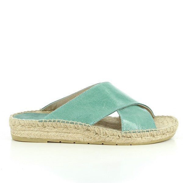 A pair of Calzanor 1809 Cross-Strap Espadrilles in a vibrant turquoise shade, radiating a lively and refreshing vibe. The soft leather upper features an elegant cross-strap design that provides both style and comfort. Set on a natural yute sole, these espadrilles combine eco-friendliness with a fun pop of color, perfect for brightening up any outfit during sunny days.