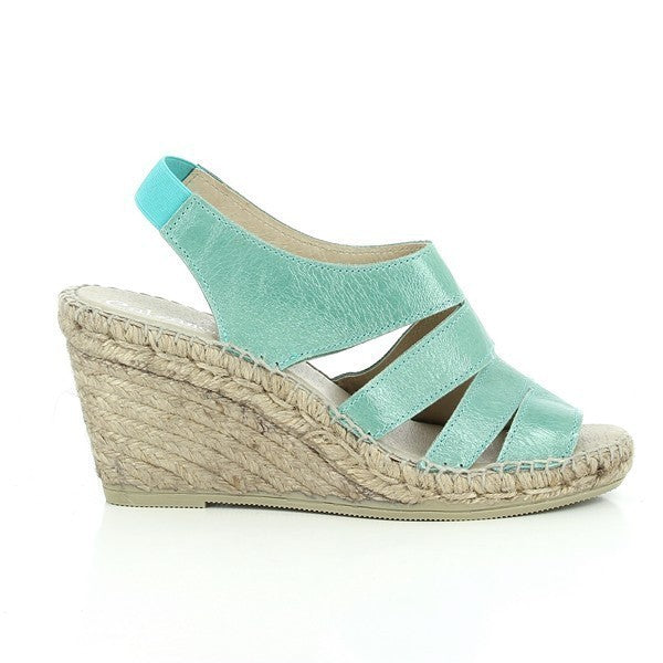 The image features a pair of Calzanor 1856 Turquoise Slingback Espadrilles, showcased against a clean, light background. The vibrant turquoise leather upper stands out, exuding a fresh and summery feel. Hand-stitched detailing along the edges highlights the espadrille’s artisanal craftsmanship. The open slingback design adds an airy look, perfect for warm weather. A natural jute sole with an 8cm platform gives the shoes a subtle lift while maintaining a casual yet stylish appeal. 