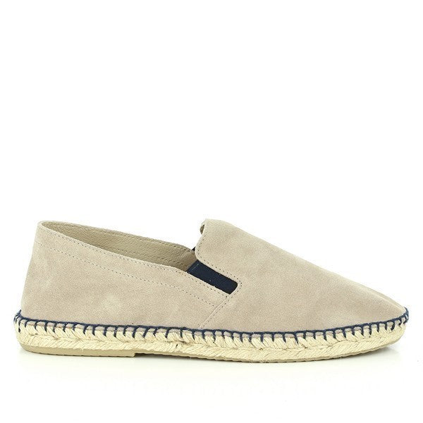 The photo showcases a pair of Calzanor 1980 Natural Espadrilles. The shoes feature a soft, natural-toned leather upper with a rustic, matte finish that highlights their artisanal quality. A hand-stitched jute sole, with a natural texture and tone, provides an eco-friendly foundation. The espadrilles have a classic round toe and a subtle 2 cm platform that adds comfort and a slight lift. The interior lining is also made of leather, ensuring breathability and comfort.