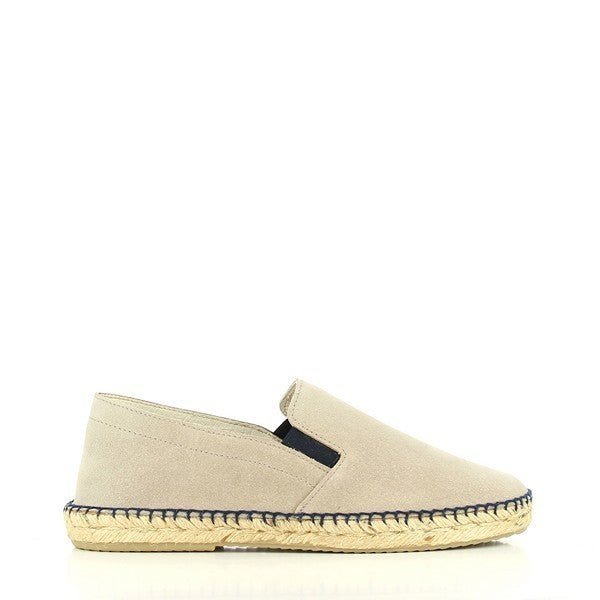 The photo features a pair of Calzanor 1980 Taupe Espadrilles, showcasing their elegant and understated design. The soft taupe leather upper has a subtle texture, exuding a chic yet casual appeal. A hand-stitched jute sole complements the upper, highlighting the eco-friendly craftsmanship. The espadrilles have a classic round toe and a comfortable 2 cm platform, providing a slight lift while maintaining ease of wear. 