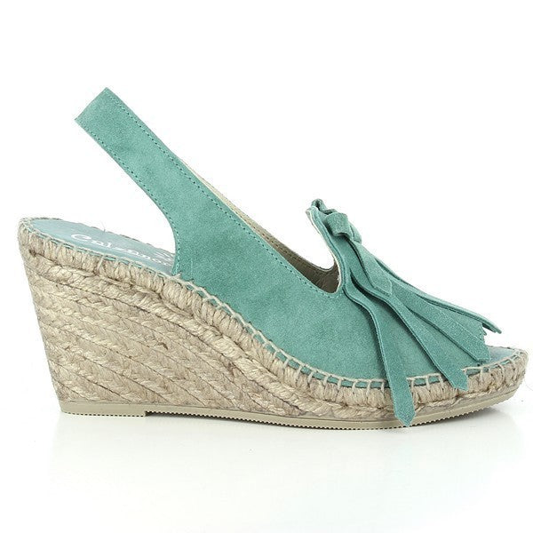 The image showcases the Calzanor 2015 Green Slingback Espadrilles, highlighting their artisanal quality and stylish design. These women’s espadrilles feature a rich green leather upper with a natural jute sole, hand-stitched with precision to emphasize craftsmanship. The slingback strap adds a secure fit, while the 9 cm platform heel gives a subtle lift. A soft leather lining peeks through the rounded toe shape, hinting at the comfort within. 