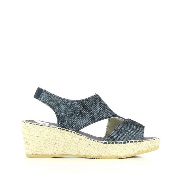 The image features the Calzanor 2042 Navy Slingback Espadrilles elegantly displayed against a soft, neutral backdrop. The rich navy leather upper shines subtly, accentuating its luxurious texture and sophisticated design. The slingback strap gently curves around the heel, ensuring a secure fit, while the soft leather lining is visible at the opening. The natural jute-wrapped sole contrasts beautifully with the navy leather, highlighting the artisanal craftsmanship. 
