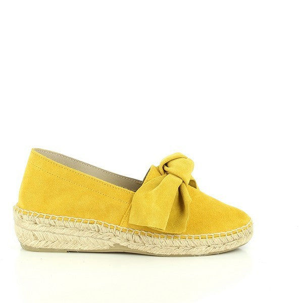 The Calzanor 2045 Yellow Ribbon Espadrilles are beautifully presented, showcasing their vibrant yellow leather upper adorned with playful ribbon accents. The cheerful color pops against a neutral background, inviting attention to their stylish design. The espadrilles feature a round toe shape, providing a comfortable and roomy fit, while the jute sole adds a touch of classic espadrille charm.