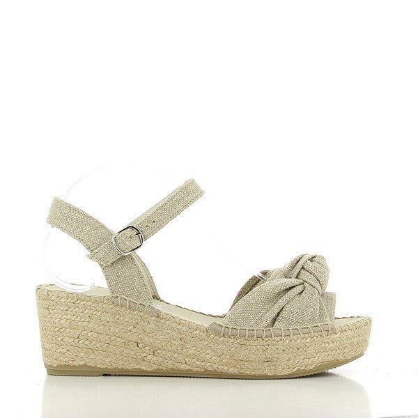 A pair of Calzanor 2103 Nude Slingback Espadrilles is elegantly displayed on a textured white surface. The espadrilles feature a soft leather upper in a light nude shade, complemented by a rounded toe and a delicate slingback strap. The jute-wrapped sole adds a touch of classic charm, while the synthetic sole enhances durability. The overall look is sophisticated and stylish, perfect for a casual yet chic outfit. Soft natural lighting highlights the textures of the leather and jute.