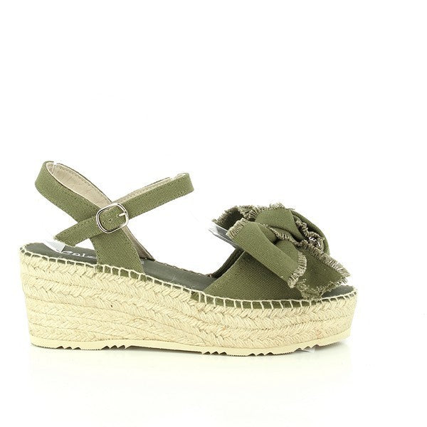 A pair of Calzanor 2235 Khaki Slingback Espadrilles displayed elegantly on a light, textured background. The shoes feature a stylish khaki fabric upper adorned with a decorative front ribbon, adding a touch of femininity. The 7cm jute-wrapped platform heel elevates the overall design, showcasing a natural and earthy aesthetic. The round toe shape and slingback strap provide a chic silhouette, perfect for warm weather. The soft tones of the fabric blend seamlessly with the natural materials.