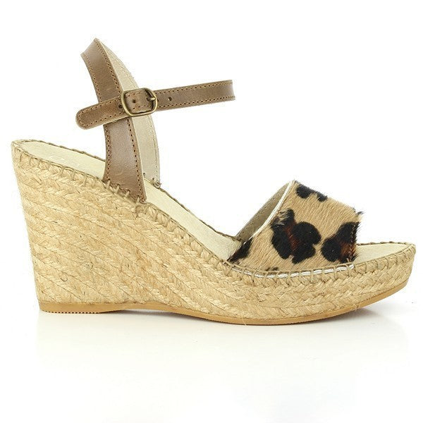 A pair of Calzanor 743 Leopard Slingback Wedge Espadrilles displayed on a wooden surface. The espadrilles feature a stylish leopard print leather upper, complemented by a soft leather lining. The 10cm wedge heel adds height while ensuring stability, making them perfect for both casual and formal occasions. The round toe design enhances comfort, while the eco-friendly jute sole showcases the brand’s commitment to sustainability.