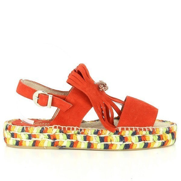 The image features a pair of Calzanor 95017FPO Orange Slingback Espadrilles. The espadrilles are crafted from soft orange leather, showcasing a round toe and a slingback design with a secure adjustable strap. The soles are made from eco-friendly, flexible yute fiber, providing both comfort and sustainability. The 3cm heel-platform height adds a subtle lift while maintaining all-day wearability. 
