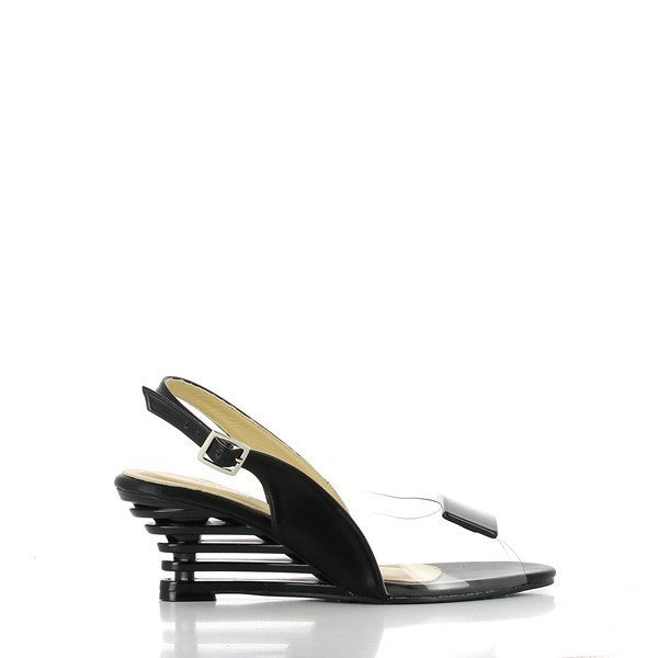 A pair of Dalessi Dali Black Slingback Heels set against a neutral background, highlighting their modern, elegant design. The heels feature a sleek black synthetic upper with a transparent front panel, giving a chic, airy look. The unique 6.5 cm decorative heel adds an artistic touch, making these shoes stand out. The rounded toe and soft leather lining enhance comfort, while the slingback strap provides a secure fit. 