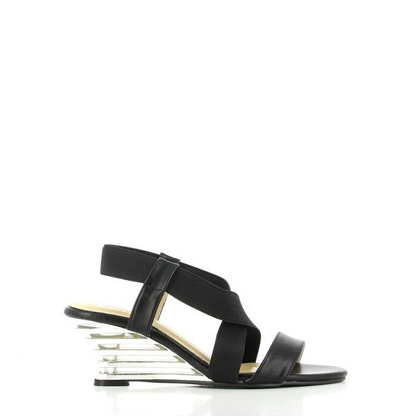 The Dalessi Delussi Black Slingback Sandals are shown from the side, highlighting the sleek black leather upper and a unique 7 cm transparent wedge heel. The elastic slingback strap wraps around the heel comfortably, providing a secure fit while adding a touch of style. The soft leather lining is visible along the edges, promising comfort with every step. The round toe shape offers a relaxed fit, and the synthetic sole is crafted for durability. 
