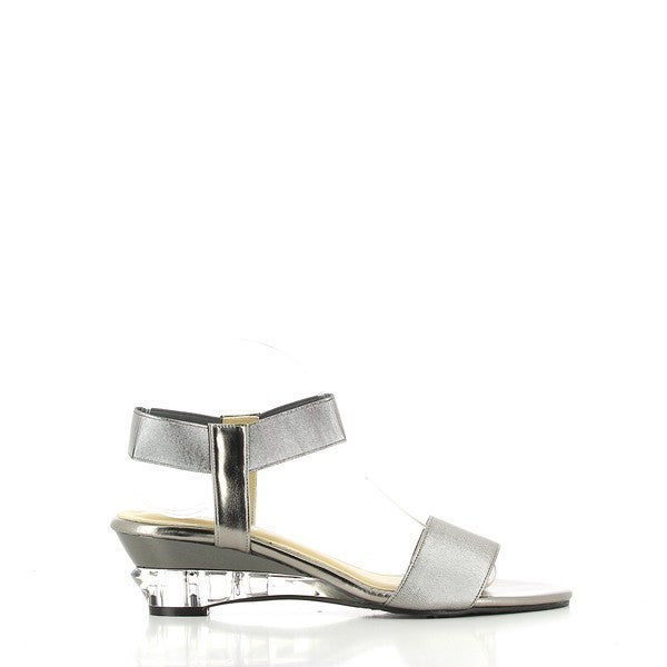 The Dalessi Deluxe Pewter Slingback Sandals are shown from the side, highlighting the smooth pewter leather upper and the stylish 5.5 cm transparent wedge heel. The round toe shape offers a comfortable fit, and the overall design is sleek and elegant.

