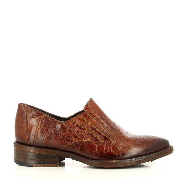 The Felmini C055 Cognac Slide-On Shoes feature a sleek, smooth leather upper with a clean, minimalist design. The round toe and low profile provide a chic, contemporary look.