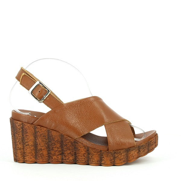 A clean profile showcasing the elegant tan leather cross-straps, the cork wedge sole with an 8cm height, and the adjustable slingback strap resting neatly on the back.

