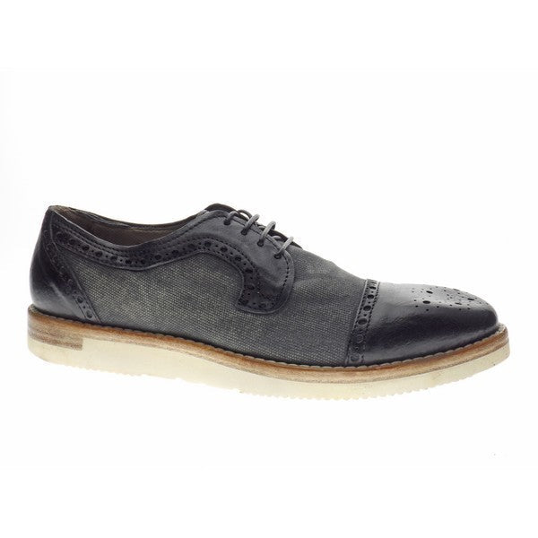 A profile view of the Forte 2166 Black Lace-Up Men's Shoes, showcasing the sleek black leather upper, intricate brogue details along the seams, and the rounded toe design.