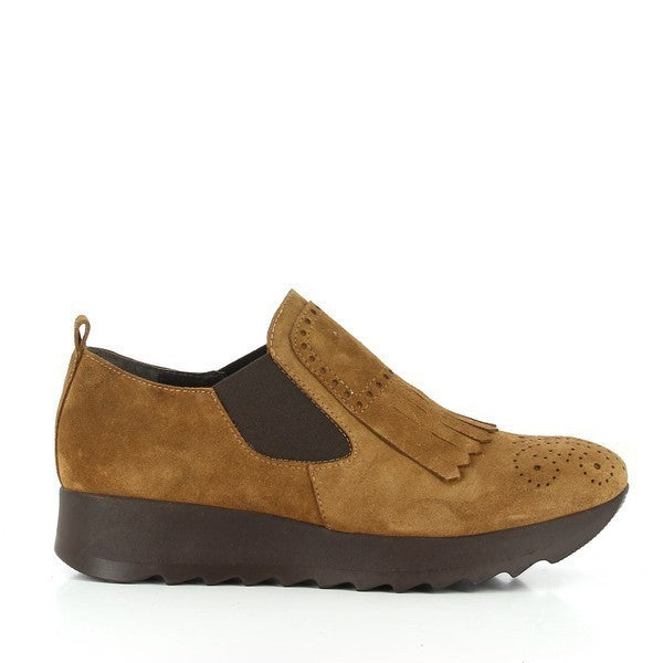 A clear profile of the tan suede slip-on shoe, highlighting its smooth upper, round toe, and the chic front fringe detail that adds a touch of sophistication.