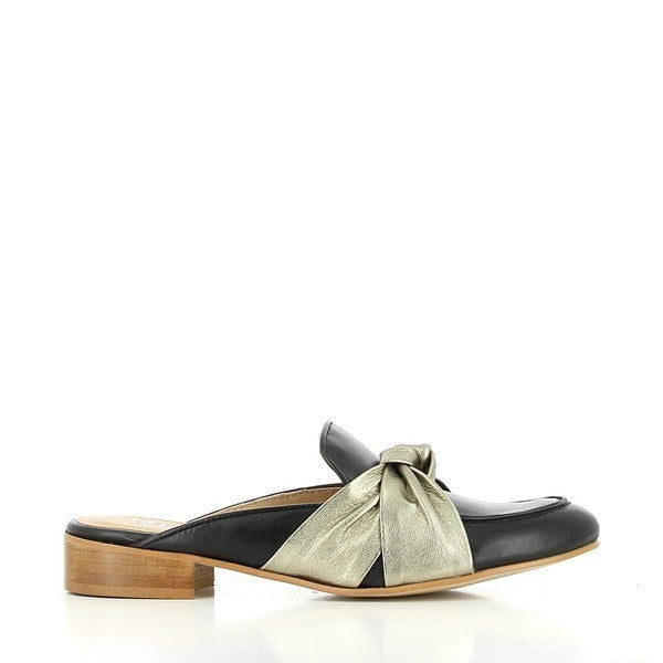 A sleek side profile of the black leather mule, highlighting its elegant round toe, smooth leather upper, and chic gold decorative bow at the front.