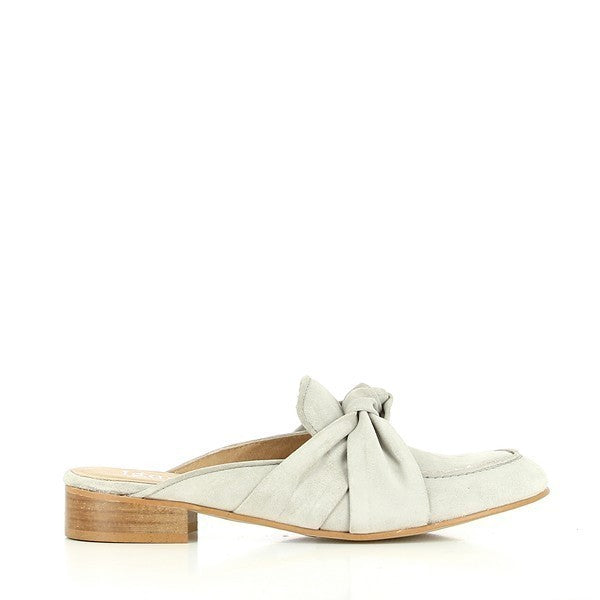 A clean side profile of the silver leather mule, showcasing its smooth, shiny upper, round toe, and elegant, large decorative bow at the front.