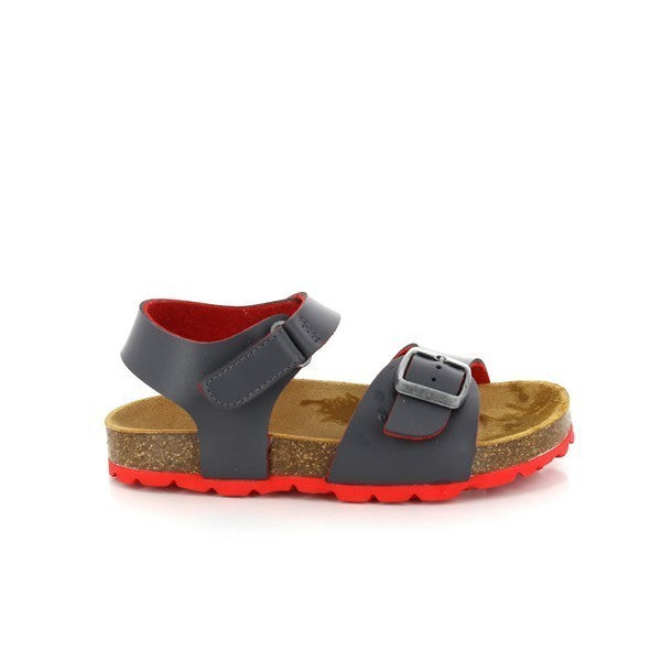 A pair of Plakton 115380 Grey Slingback Kids Sandals displayed on a light background. The sandals feature a sleek grey synthetic upper, adjustable straps with a buckle and Velcro for a secure fit, and a comfortable cork sole with a 2cm platform. The round toe shape ensures ample room for movement, showcasing the perfect blend of style, comfort, and durability. Ideal for active kids and eco-conscious families.